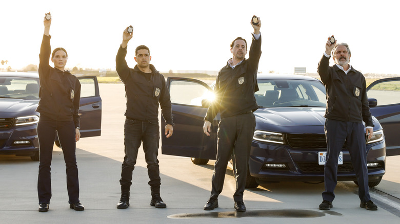 NCIS team holding up badges