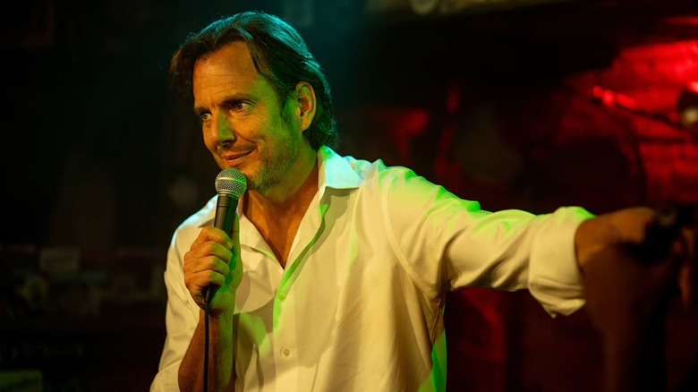 Alex Novak holding a microphone for stand-up in 