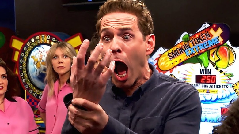 Dennis looks at his own hand, screaming