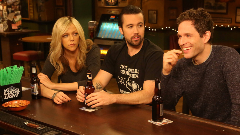 Dee, Mac, and Dennis sitting at the bar of Paddy's Pub