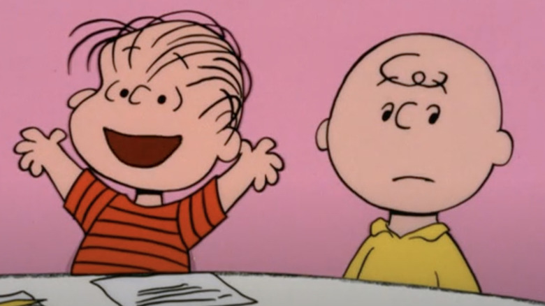 Linus smiling beside a frowning Charlie Brown