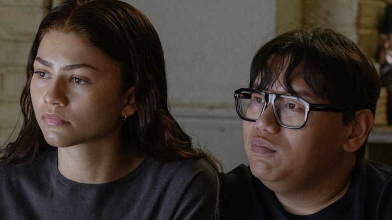 Ned and MJ sitting on a couch in their apartment in 