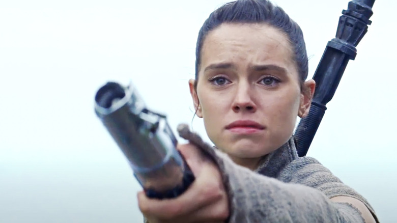 Rey handing lightsaber