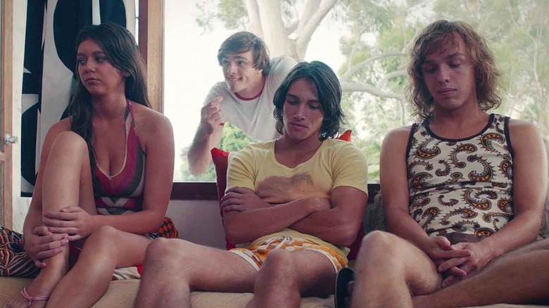 Bec, Liam, and Cal sitting on a couch, with Rooster standing behind in "Swinging Safari"