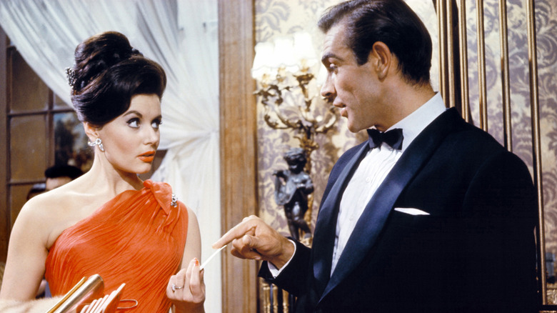 Bond hands a card to Sylvia in "Dr. No" (1962)