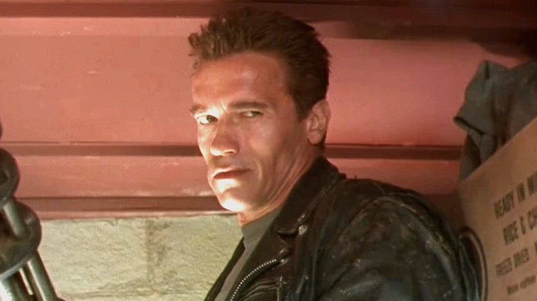 The Terminator stands against a wall