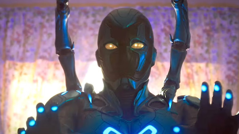 Jaime Reyes wearing the Blue Beetle exoskeleton and holding up his hands