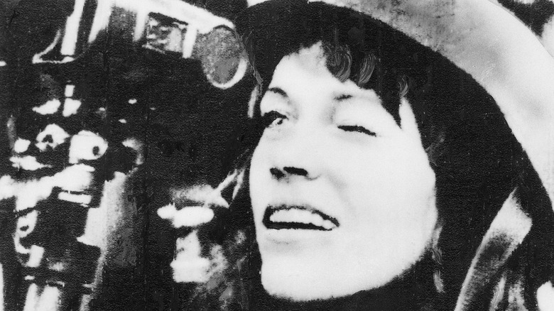 Jane Fonda squints through a gun sight while touring North Vietnam