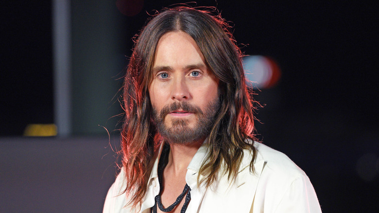 Jared Leto looking at the camera with red light behind him
