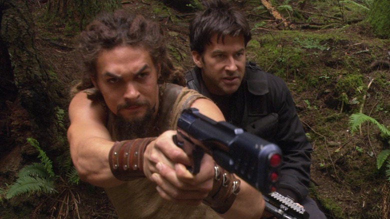 Ronon Dex aiming his weapon under cover with Col. Sheppard