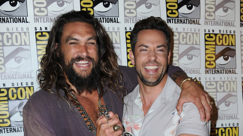 Jason Momoa and Zachary Levi smiling and posing together at Comic Con