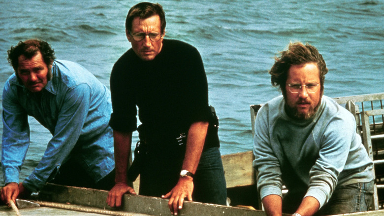 Brody, Hooper, and Quint leaning over the edge of a boat
