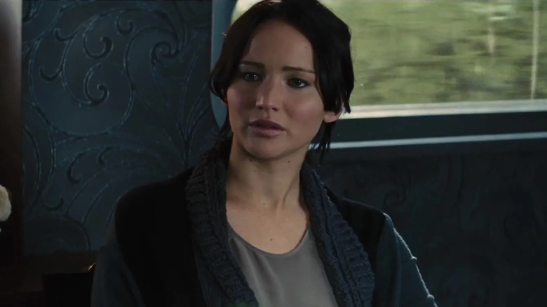 Katniss sitting looking curious