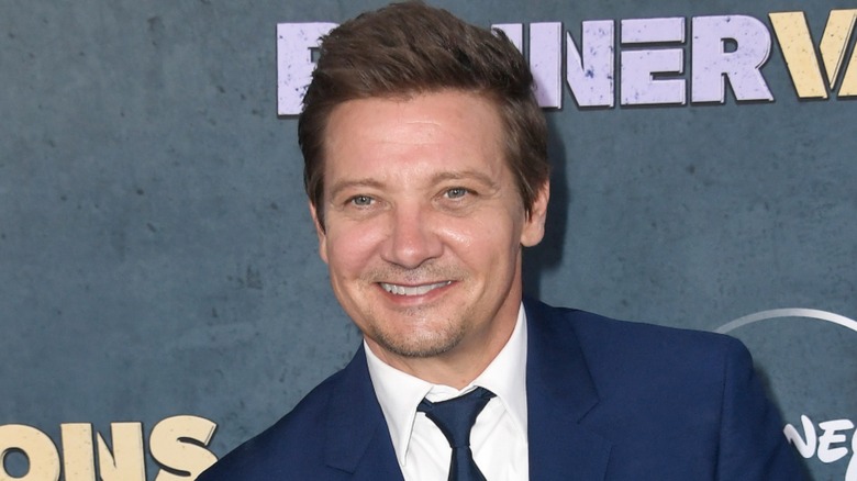 Jeremy Renner smiling in suit