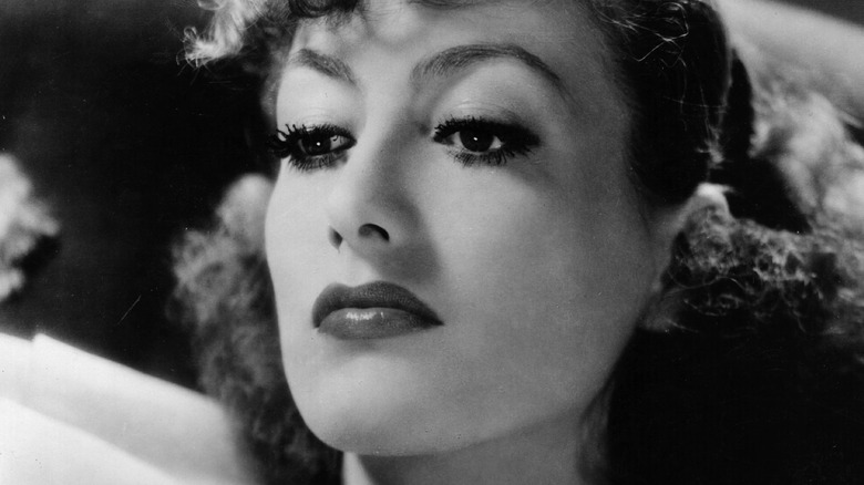 Joan Crawford looks down frowning