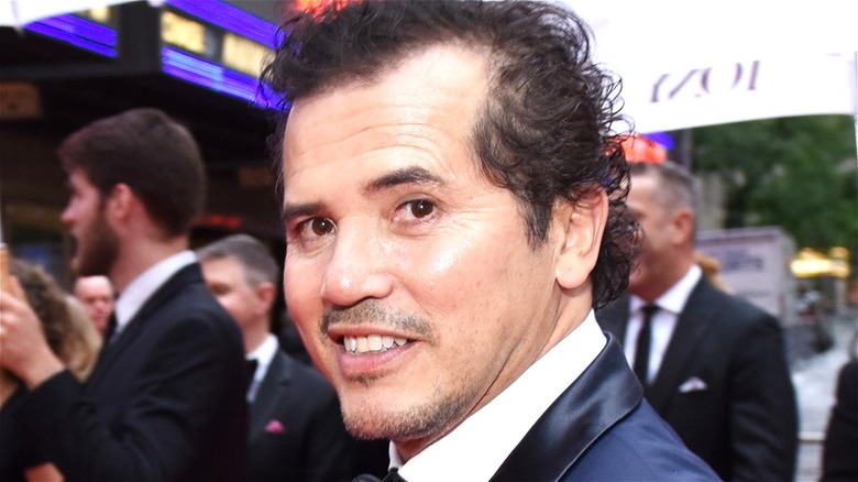 John Leguizamo wearing blue suit, looking sideways