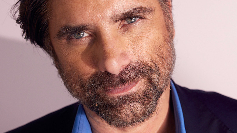 John Stamos smirking in a photograph