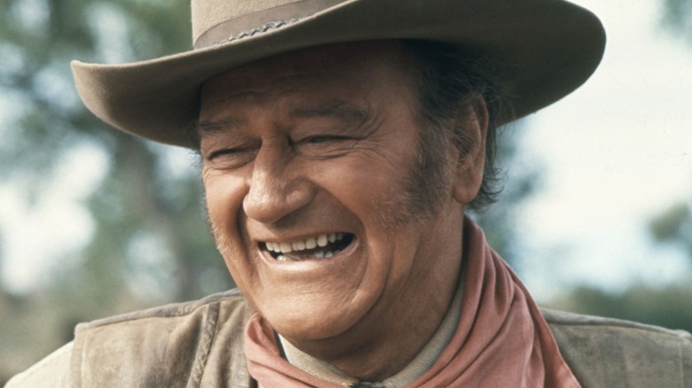 John Wayne smiles on the set of a movie