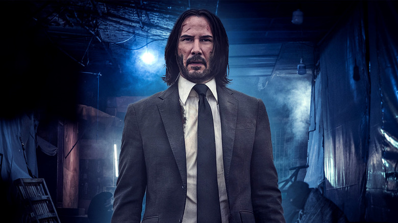 John Wick standing in a dark alleyway