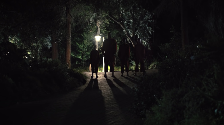 The tethered hold hands in a driveway