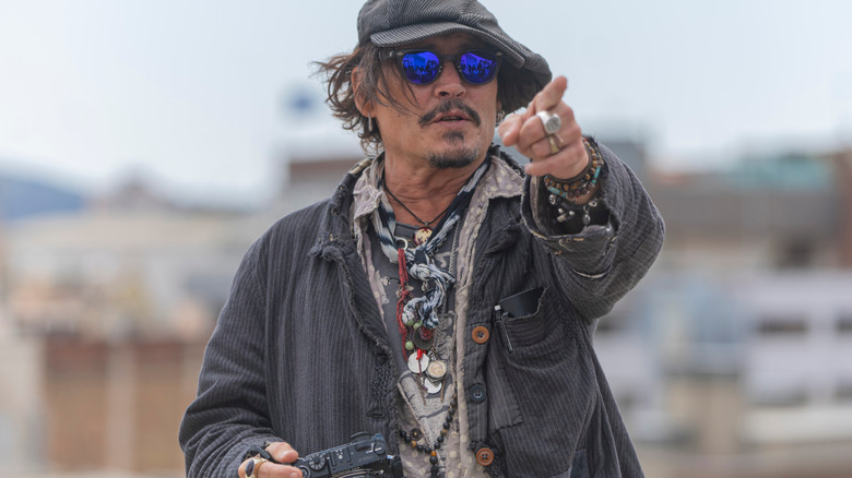 Johnny Depp pointing with a camera in hand