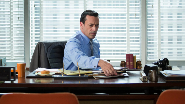 Don looking concerned at something on his desk on Mad Men