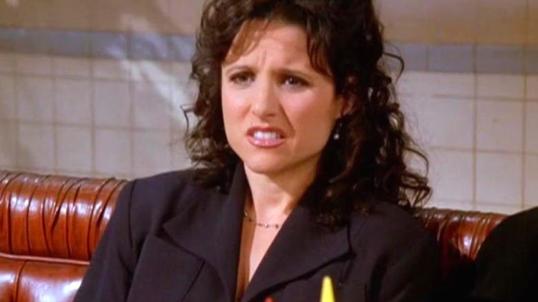 Elaine Benes sitting in a booth