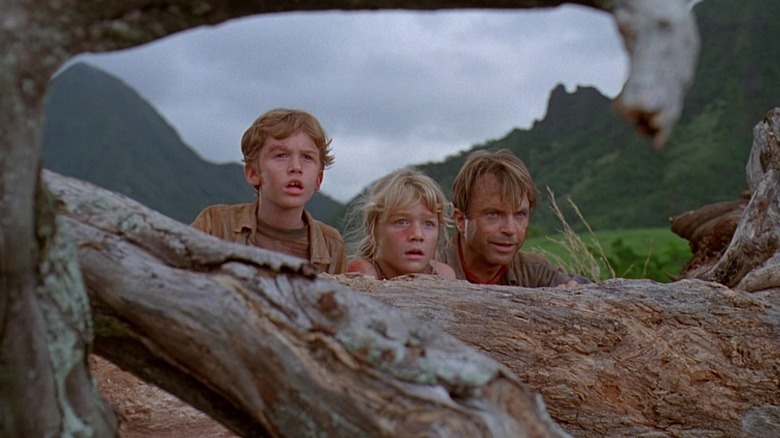 Grant, Lex, and Tim hiding behind log