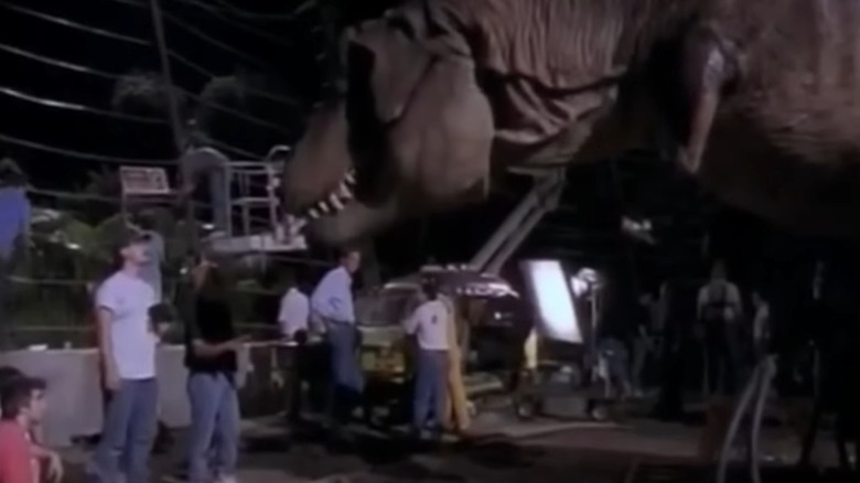 Effects person putting red meat on T-Rex robot