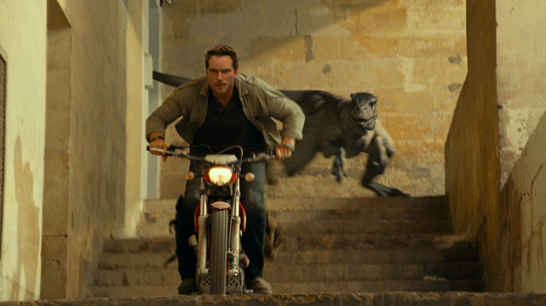 Pratt on motorcycle chased by dinosaur