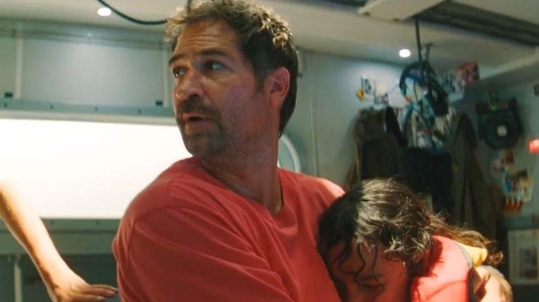 Reuben clutches his youngest daughter tightly in "Jurassic World Rebirth" (2025)