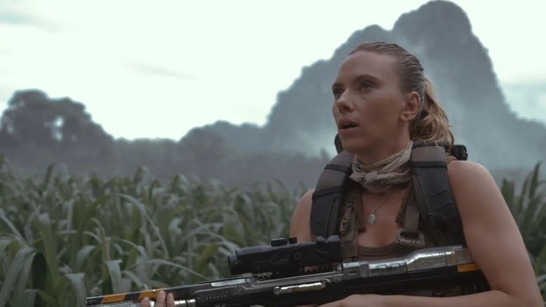 Zora Bennett prepares to attack in tall grass in "Jurassic World Rebirth" (2025)