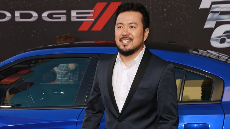 Justin Lin in front of a car