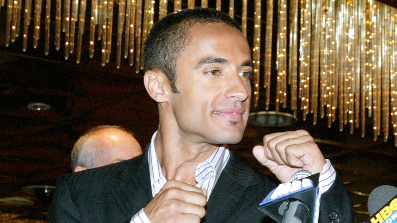 Kamar de los Reyes raising fists in front of microphones