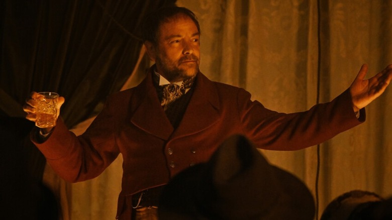 Mark Sheppard Hagan holding a glass and performing 