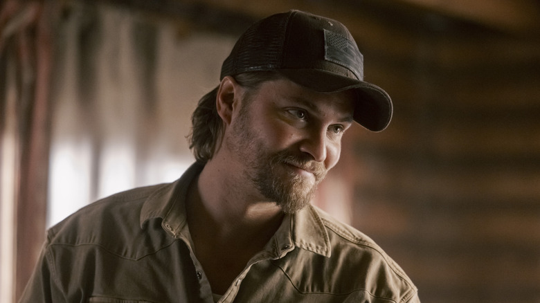 Kayce Dutton leaning over and grinning in 