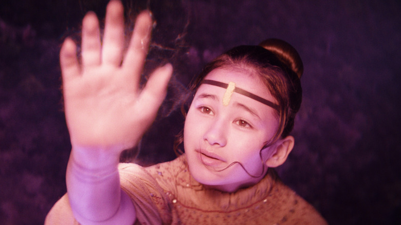 Jia holding up hand to glowing light in Godzilla x Kong: The New Empire (2024)
