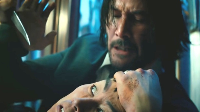 John Wick holding a knife up to opponent