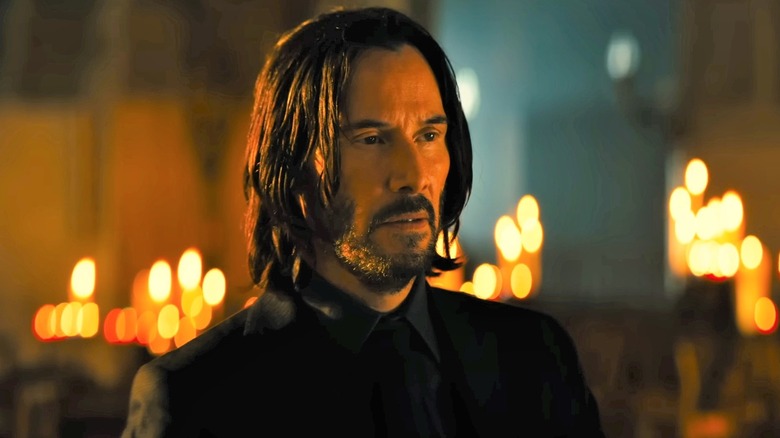 John Wick in front of candles