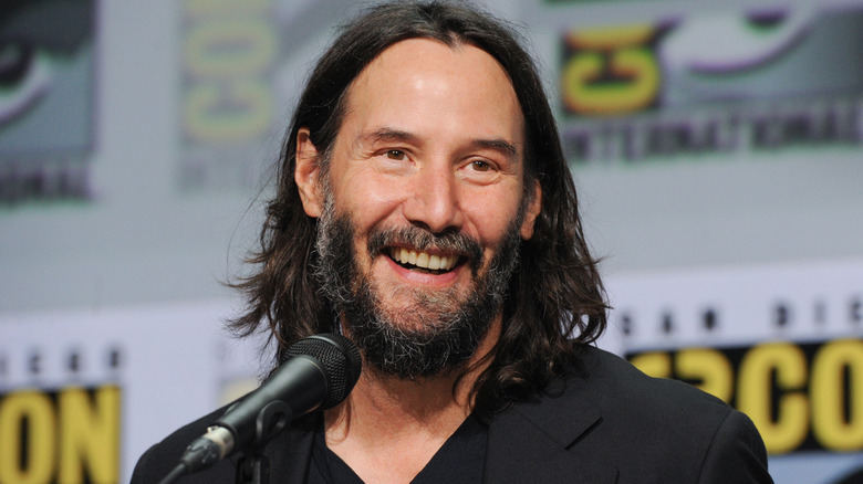 Keanu Reeves speaking into microphone