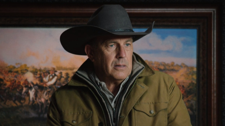 John Dutton stands in front of a painting