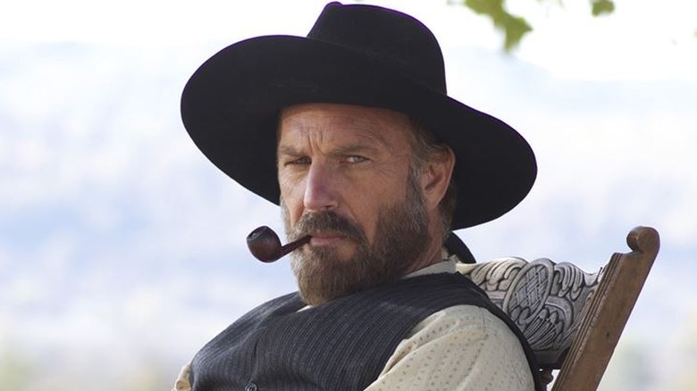 Kevin Costner smokes a pipe