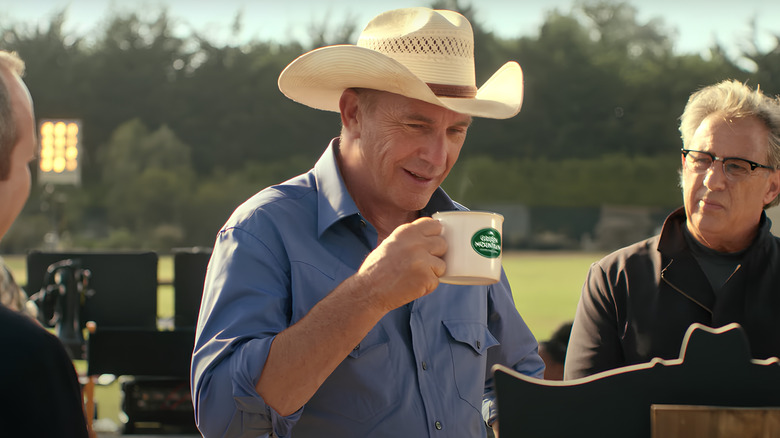 Kevin Costner holding a mug