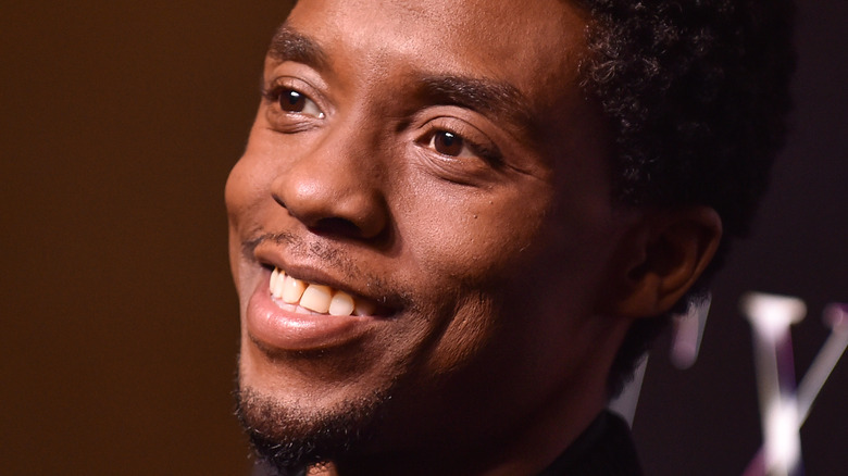 Chadwick Boseman smiling for the press