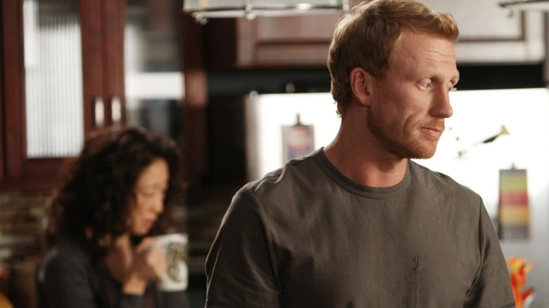 Owen in the kitchen with Cristina behind him on Grey's Anatomy
