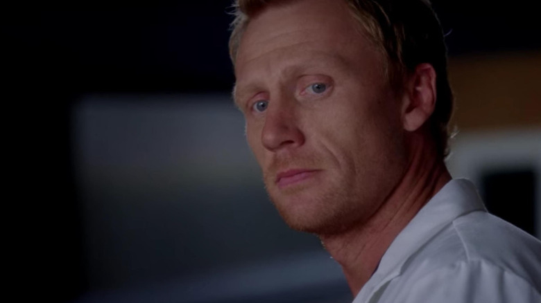 Owen looking down at something on Grey's Anatomy