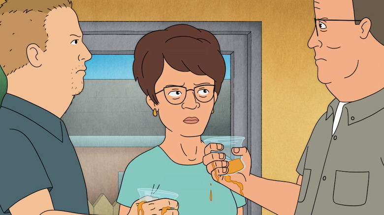 An annoyed Peggy Hill standing between Hank and Bobby