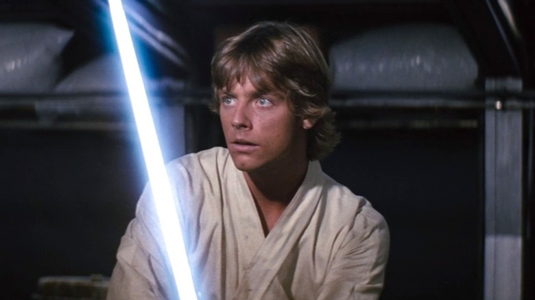 Luke holds his lightsaber