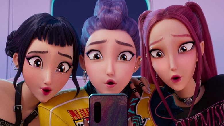 Rumi, Zoey, and Mira stare at smartphone in KPop Demon Hunters