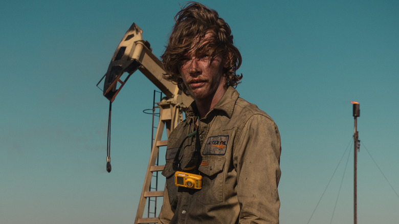 Cooper Norris stands in the oil field with a dirty face in "Landman"